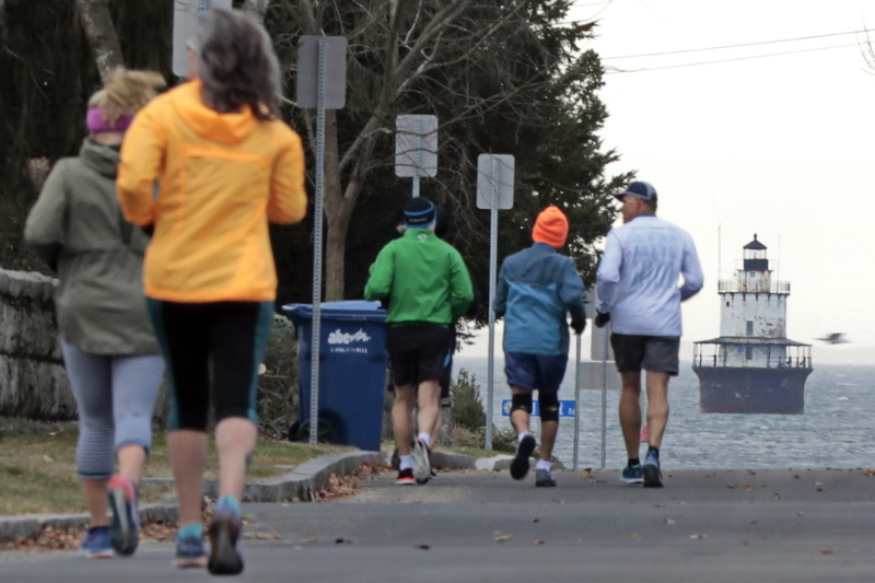 Runners make their way down Fort Street in Fairhaven, MA toward the iconic Butler Flats lighthouse off in the distance.  PHOTO PETER PEREIRA