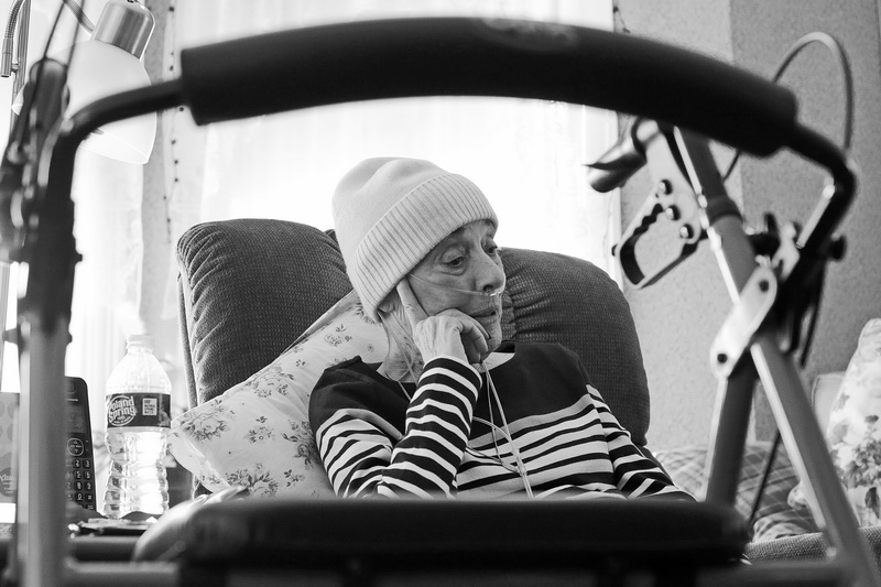 A walker can be seen in the foreground, as Rachel Jupin sits on her couch at home.  Rachel Jupin a long time New Bedford High School literature teacher, is now fighting a battle with stage 4 lung cancer, and was forced to retire, a decision that pains her to talk about.   PHOTO PETER PEREIRA