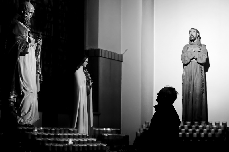 A parishioner is seen praying to one of the saints inside of Our Lady's Chapel in downtown New Bedford, MA.  PHOTO PETER PEREIRA