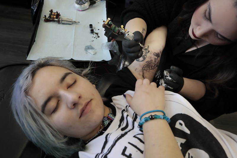 Rachel Garnett gives Hannah Dias a new tattoo on her art at the New Bedford Tattoo Company in downtown New Bedford, MA. PHOTO PETER PEREIRA