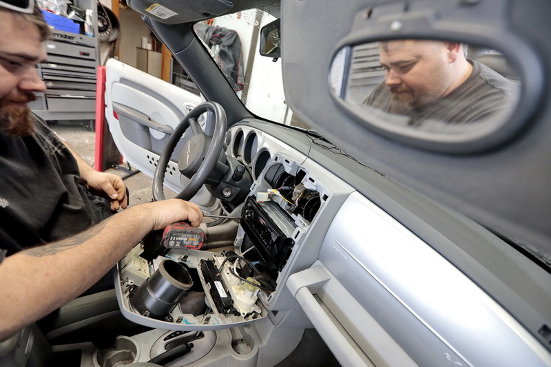 Richie's Auto Radio owner Ken Abrantes, installs a new handsfree ready radio in a Chrystler PT Cuiser at his shop in Dartmouth., MA.  Handsfree driving rules will change at the end of this month.  PHOTO PETER PEREIRA