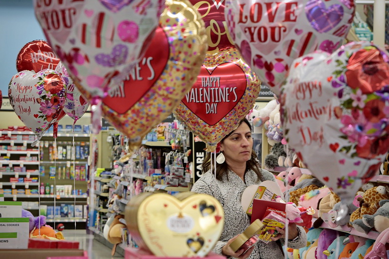 Jessica DeMedeiros is surrounded by Valentines Day themed balloons as she picks out some gifts for her loved ones at Walgreens on Kempton Street in New Bedford., MA in preparation for Valentine's Day tomorrow.  PHOTO PETER PEREIRA