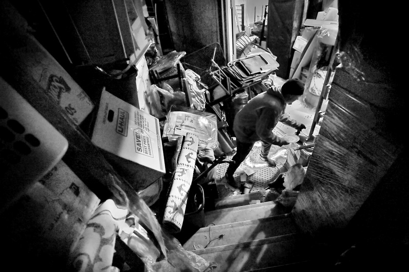 A worker places some dishes onto a pile on the side of the corridor of the old Orpheum theater in New Bedford, MA.  The Orpheum Theater was constructed in 1912 and is thought to be th second oldest in the county, is now being used by the owner to store items taken from properties which renters have failed to pay rent.  PHOTO PETER PEREIRA