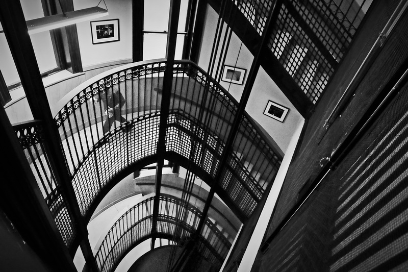 A man walks up the staircase that spirals around the enclosure of the conic elevator inside of New Bedford City Hall. This elevator was constructed in 1906 and is thought to be the oldest running elevator in the country. 