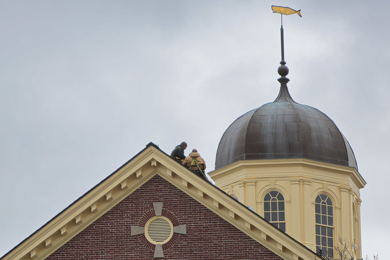 Roofers are dwarfed by the iconic cupola of the Whaling Museum, as they replace some damaged shingles.   PHOTO PETER PEREIRA