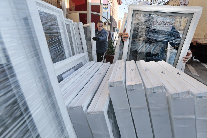 Joe Pereira, center owner, and his staff unload over 100 windows in front of Precision Window & Kitchen on Acushnet Avenue in the north end of New Bedford. Mr. Pereira has taken various precautions regarding the coronavirus pandemic, with hand sanitizer in every truck and emphasis on installing at properties with no occupancy.   PHOTO PETER PEREIRA