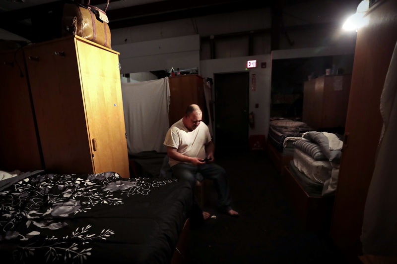 Alan Guilmette puts on a pair of socks after waking up at the House of Hope in New Bedford.  The House of Hope houses over 50 homeless people and has self  quarantined for over two weeks due to the coronavirus pandemic.  No one is allowed in or out of the shelter.   PHOTO PETER PEREIRA