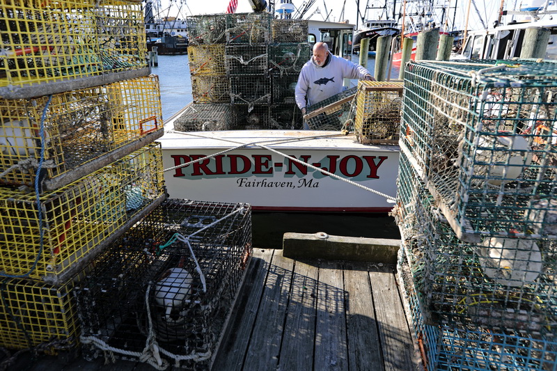 John Moniz loads lobster traps onto his boat, Pride-N-Joy, docked in Fairhaven.  After being laid-off from Titleist, Mr. Moniz has decided to go out on his boat to catch some lobsters, knowing that the prices are extremely low right now. Some of his contemporaries have started to sell lobsters directly to the public.