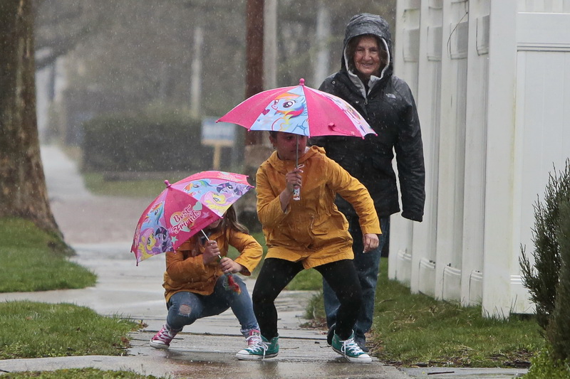 (l to r) Blair Ferreira and her sister Sophie Ferreira do a little dancing, as they go for a rain walk with their great aunt Bonnie Philla in Fairhaven, MA. PHOTO PETER PEREIRA