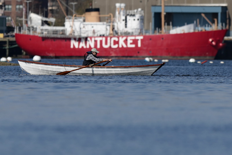 A man takes adavantage of the perfect weather to head out for a morning row from Fairhaven acoss the Nantucket Lighthouse ship currently docked at State Pier in New Bedford, MA.  PHOTO PETER PEREIRA