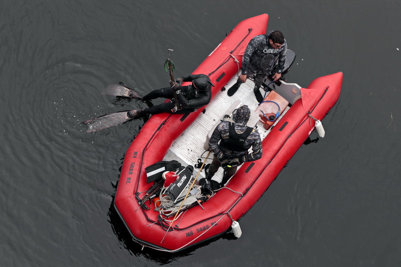 Divers prepare to dive into the dark waters under the Route 88 bridge in Westport, MA in search of tautog blackfish.