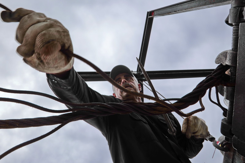 Charlie Albernaz of New Bedford Ship Supply, uses a pick and strength to weave the steel cable around itself, after creating an eye splice for a New Bedford scalloper. PHOTO PETER PEREIRA