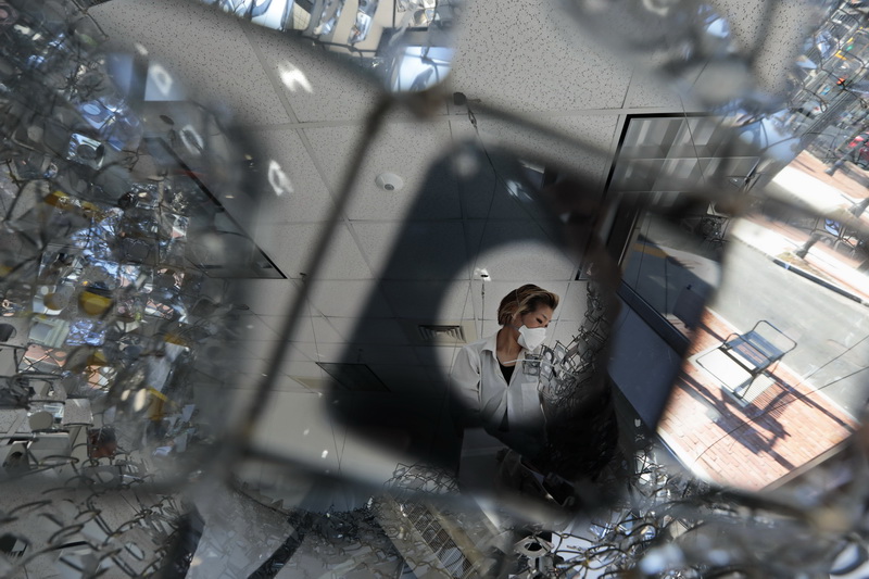 Artist Soo Sunny is surround by her work as she installs her 'Photo Kinetic Grid Revisited' piece, hanging from the ceiling of the Massachusetts Design Art and Technology Institute (DATMA) gallery at the Star Store building on Purchase Street in New Bedford, MA. 