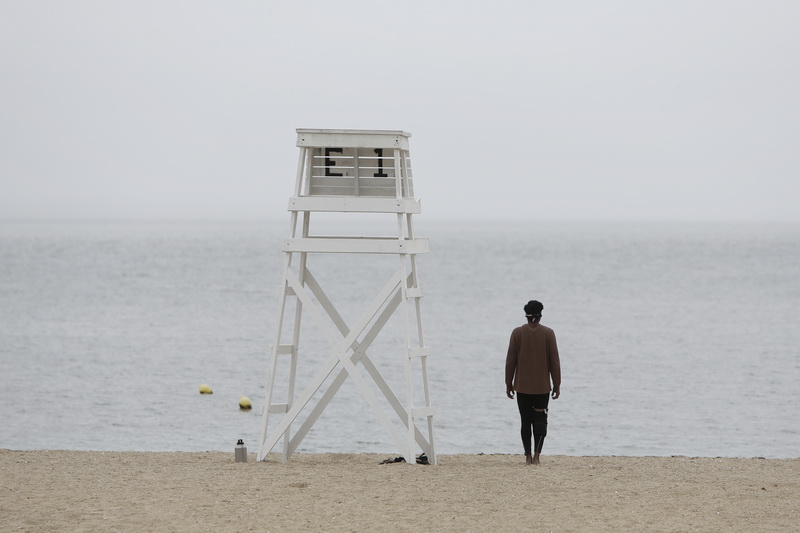 A man stands still and looks out into the fog from East Beach in the south end of New Bedford, MA between doing exercise intervals on the sand.  PHOTO PETER PEREIRA