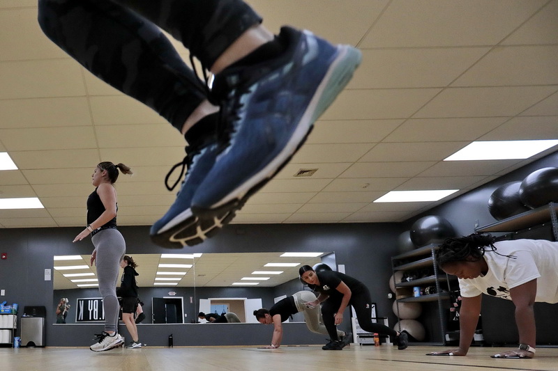 Kaitlyn Duarte, second from right, pushes her students, during an early morning training session at the F.I.T.T. by K gym on Dartmouth Street in New Bedford, MA. The gym has been closed since March, when it was forced to close due to the pandemic, and has now reopened.  PHOTO PETER PEREIRA