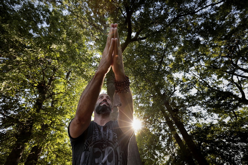 The morning sun peeks from the tree canopy beyond as Yoga instructor, Jeff Costa and fellow participants perform yoga at the Tuesdays Yoga in the Park, at Cushman Park in Fairhaven taught by Sangha New Bedford. Sangha New Bedford is scheduled to open soon at its downtown New Bedford location and begin inside sessions. There are two more free yoga sessions at Cushman Park in Fairhaven scheduled for the two upcoming Tuesdays. PHOTO PETER PEREIRA