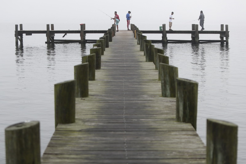 Men fish from a dock in the south end of New Bedford, MA on a very foggy morning.  PHOTO PETER PEREIRA