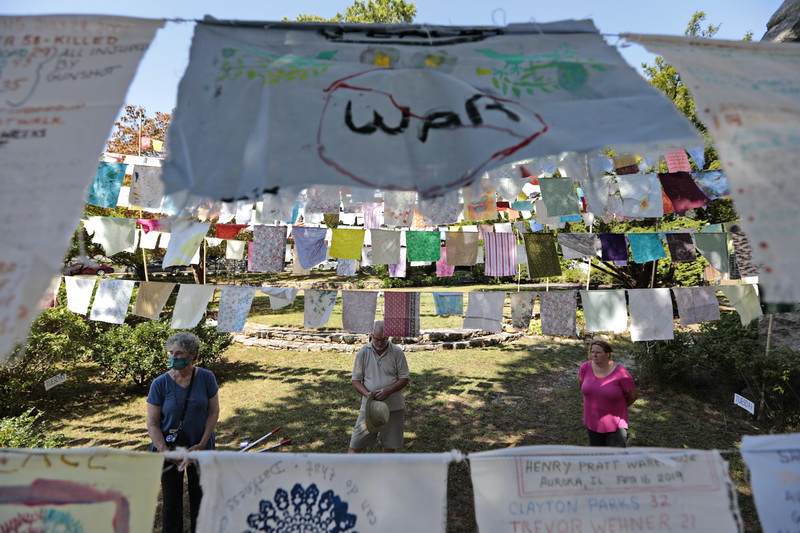 Allen's Neck Friends Meeting members hold a moment of silence after installing 765 flags, each representing someone in America who lost his or her life to gun violence, in front of the First Unitarian Church in New Bedford, MA.  The installation was on display in Westport but will now be in New Bedford for the next few weeks. PHOTO PETER PEREIRA