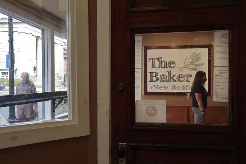 A pedestrian making his way up Pleasant Street takes a look inside, as another waits for her order to be ready at The Baker in downtown New Bedford, MA. PHOTO PETER PEREIRA