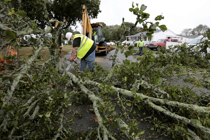 Jay Desorcy, left, and Dwayne Pinkham, of New Bedford DPI Green Space, cut a large section of a tree that fell due to the high winds across Kenney Street in the north end of New Bedford, MA. PHOTO PETER PEREIRA