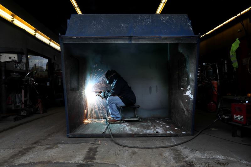 Sheroun Ivy, a welder with ABC Disposal in New Bedford, finds himself inside a six yard dumpster, replacing the entire bottom of the unity with a new metal flooring   PHOTO PETER PEREIRA