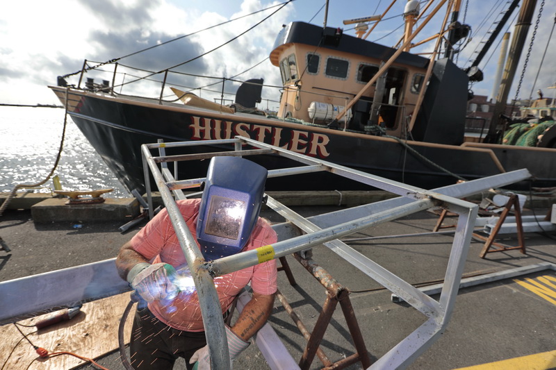 Manny Ribeira, welds the upper structure of a mast he is making for the fishing boat Yankee Rose docked in New Bedford, MA.   PHOTO PETER PEREIRA