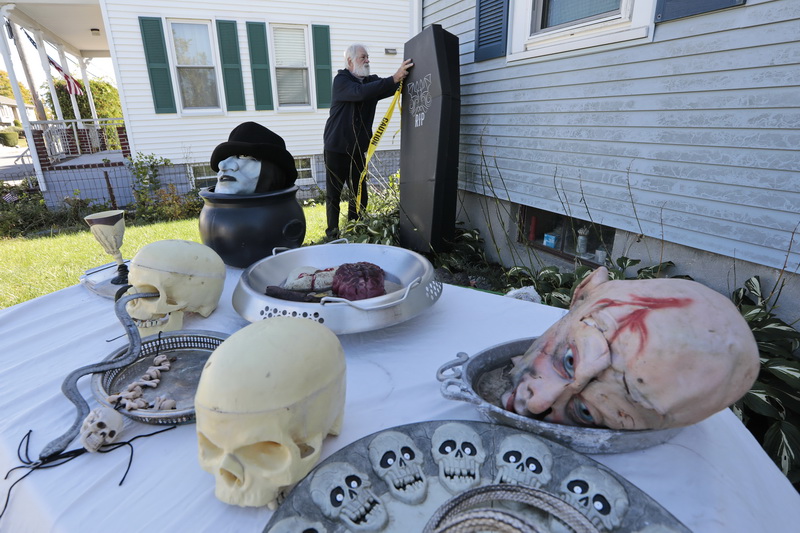 With the high winds, Leo Duval tries to tie down the cardboard coffin he is placing on the side of his home, as he assembles Halloween decorations in front of his home in New Bedford, MA. PHOTO PETER PEREIRA