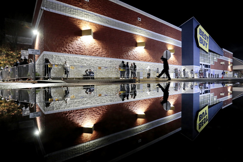 A shopper makes his way past the large puddle of water, to join the socially distanced line of people waiting to get into Best Buy in Dartmouth on Black Friday.  PHOTO PETER PEREIRA