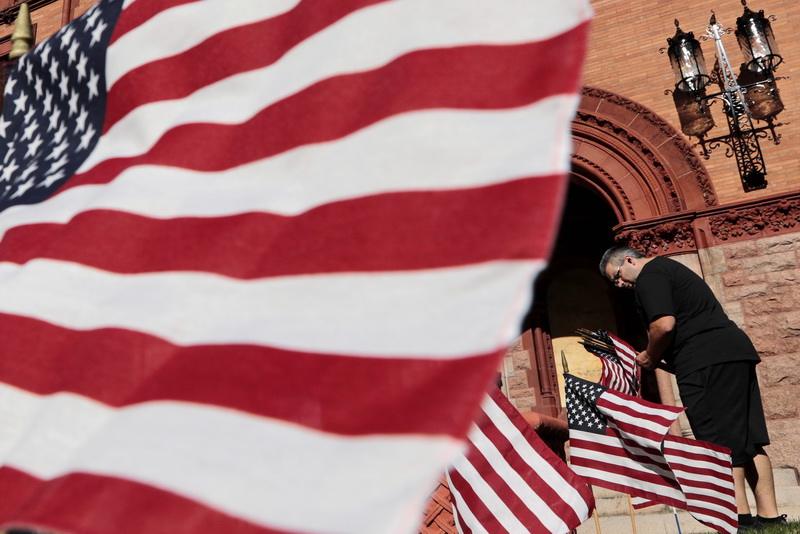 Kevin Fournier, custodian, places American flags in front of Fairhaven Town Hall in preparation for Veterans Day.   PHOTO PETER PEREIRA