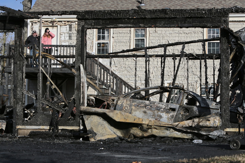 Alexandra Brum is in a state of shock as she returns home to see the aftermath of the garage which abuts her property and burned to the ground on Hamlin Street in New Bedford, MA.  Beside her is Joe Medeiros who also owns property to the left of the garage.  PHOTO PETER PEREIRA