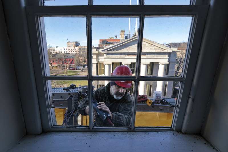 The Custom House is seen in the distance as Paul Cabral of Yates Construction is seen working on the flashing of a dormer on the top level of the Law Offices of Beauregard, Burke & Franco in downtown New Bedford which is undergoing a major external restoration.  PHOTO PETER PEREIRA