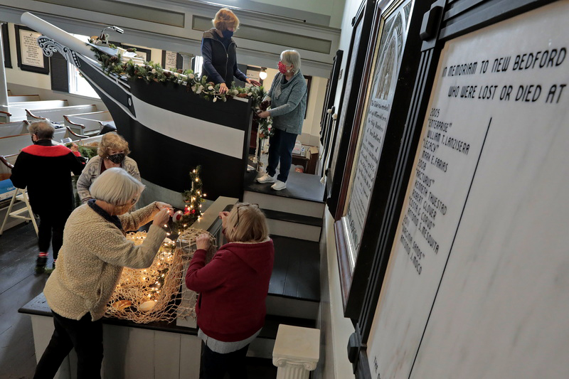 Cenotaph's with the names of New Bedford fishermen lost at sea hang on the walls as members of the Greater New Bedford Gardening Club decorate the inside of the Seamen's Bethel in downtown New Bedford in preparation for a virtual holiday concert.   PHOTO PETER PEREIRA