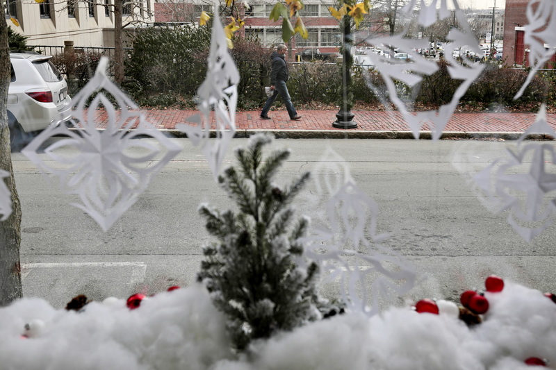 A man walks past a window at the UMass Dartmouth downtown New Bedford, MA campus, decorated with a wintry scene as part of the Sparkle at The Star Store program.    PHOTO PETER PEREIRA