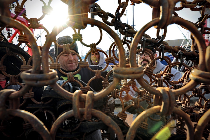 (l to r) Ozzy Peixoto, Paulo Braga and Robert Amaral work on repairing the steel rings of the dredges aboard the scalloper Elizabeth & Niki docked in New Bedford, MA. PHOTO PETER PEREIRA 