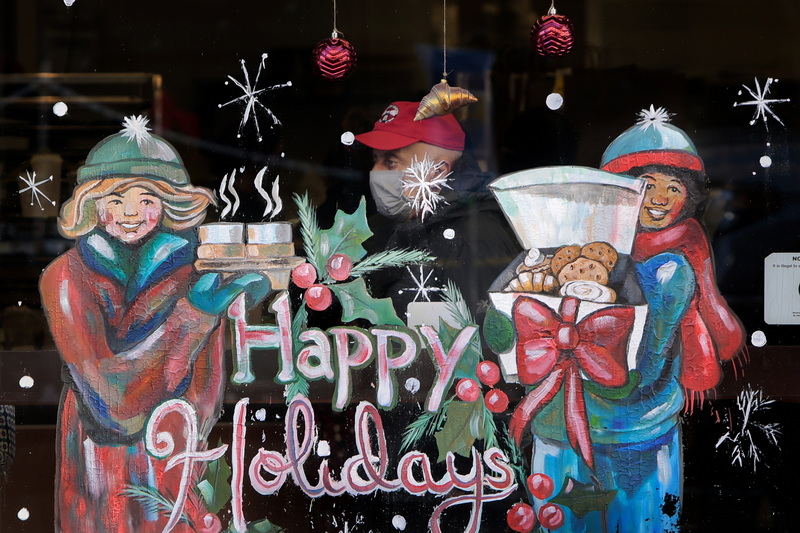 A patron waits for his order inside of The Baker in downtown New Bedford, MA as seen through the colorfully painted window.  PHOTO PETER PEREIRA 