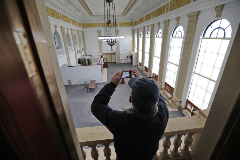 A potential buyer grabs a photo of the main hall from the second floor office of the original Merchants National Bank at the intersection of William Street and Purchase Street in downtown New Bedford, MA.  The iconic structure was built in 1915 and is now being auctioned on January 26.  PHOTO PETER PEREIRA