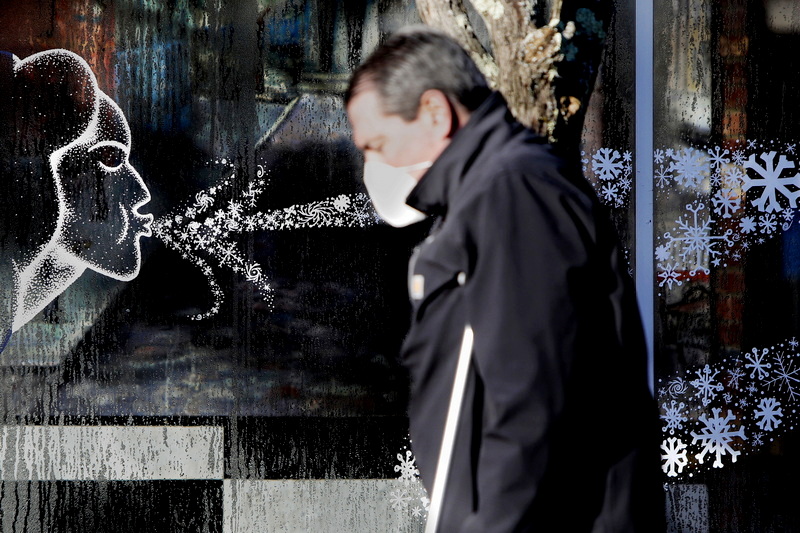 A newly installed art piece on the window of a building at the intersection of N Second Street and Union Street in downtown New Bedford, MA blows cold air toward a man walking up N Second Street as a cold front makes its way across the region.   PHOTO PETER PEREIRA