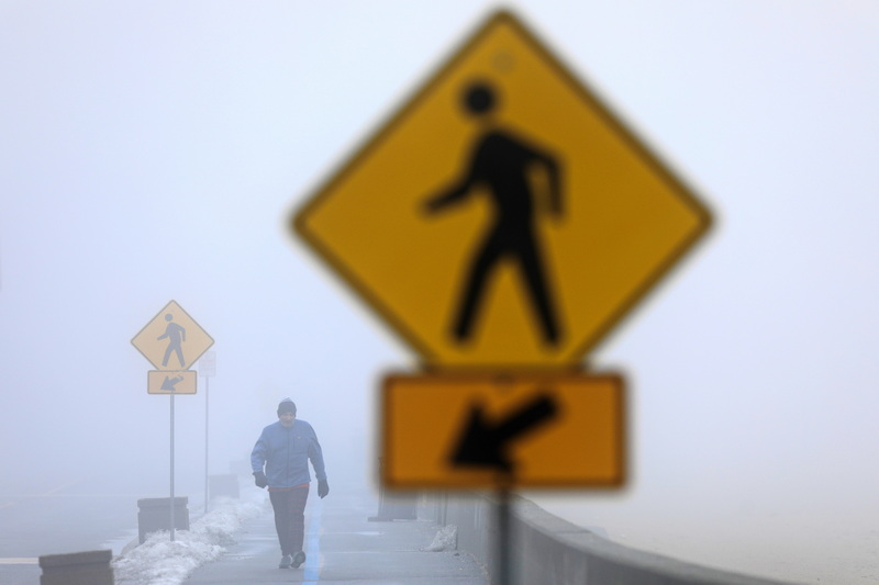 Jerry Laperriere emerges from the fog as he goes for a walk around the south end of New Bedford, MA.  PHOTO PETER PEREIRA