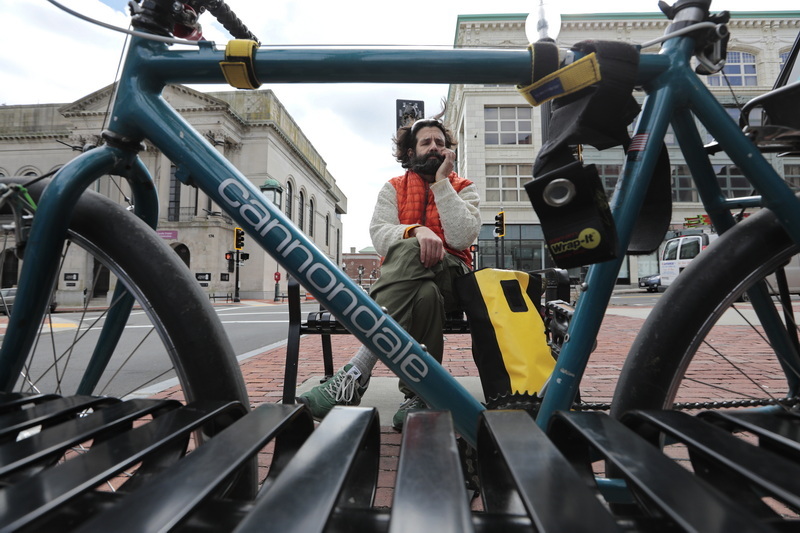 A man speaks on the phone as he enjoys a moment sitting on a bench, after riding his bike to downtown New Bedford, MA. PHOTO PETER PEREIRA