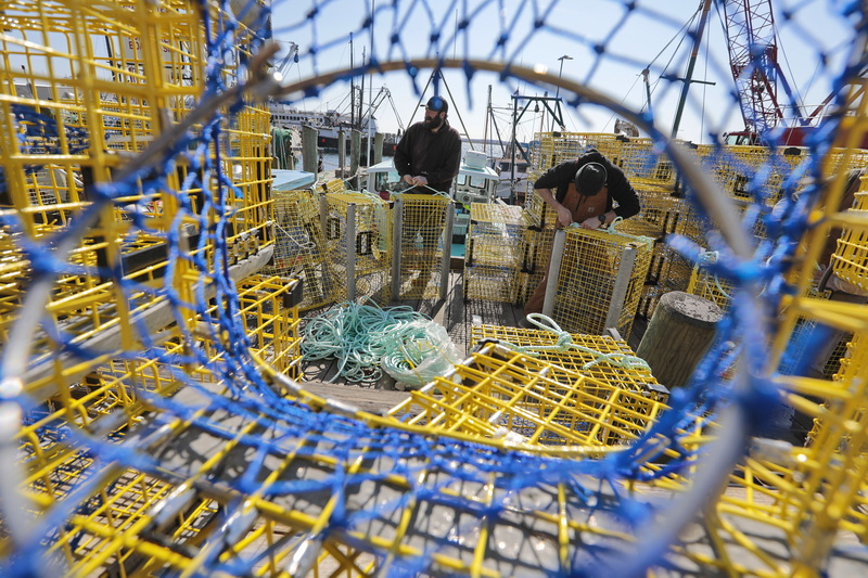 Hunter Lees, left, and Matthew Hebert prepare the 150 new traps they will be taking out aboard the Mountaineer out of Fairhaven, MA.  Mr. Lees just purchased the lobster boat and these are the new traps for the boat. PHOTO PETER PEREIRA