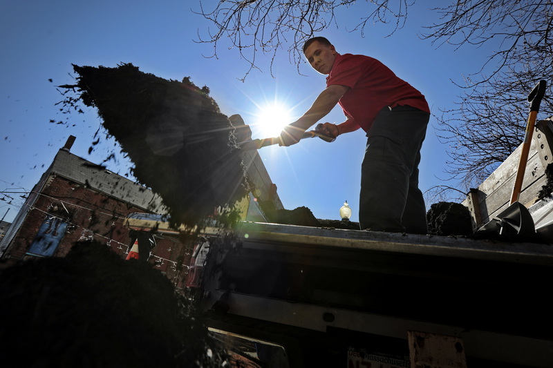 Chris LeTourneau of Elf's Landscaping unloads mulch from the back of a truck, for use at Wing's Court in downtown New Bedford, MA. PHOTO PETER PEREIRA