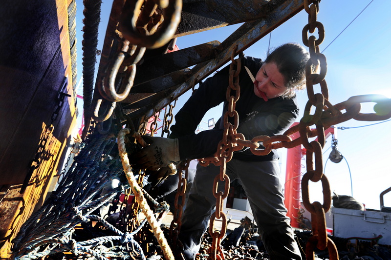 Crystal Vaughan removes the twine top from the dredge of the Reliance fishing boat, in preparation to heading back out to sea on Friday. Crystal Vaughan is the mate of the fishing boat Reliance a scalloper out of the port of New Bedford. PHOTO PETER PEREIRA