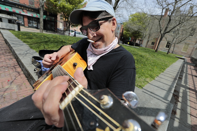 John Sedlock takes advantage of the great weather by playing his guitar at Custom House Square in downtown New Bedford, MA. PHOTO PETER PEREIRA