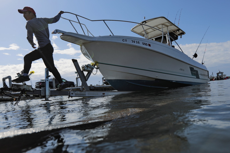 A boater hovers above the water, as he pulls his pleasure craft out of Mattapoisett harbor.  PHOTO PETER PEREIRA