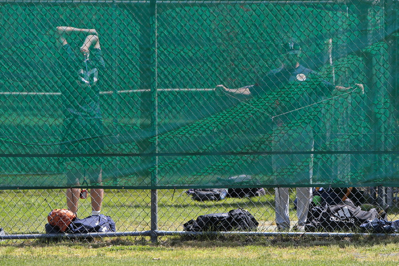 Wareham Gatemen pitchers warm up behind a green fence during their first practice session in preparation for the upcoming Cape Cod Baseball League season in Wareham, MA. PHOTO PETER PEREIRA