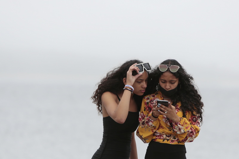 Two young women take a look at the results of photos they took of themselves on a foggy morning in New Bedford, MA. PHOTO PETER PEREIRA