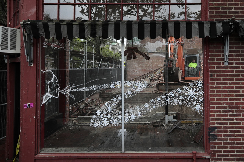 A drawing on the window of the old Naughty Dawgs seemingly blows away a demolition crew as they knock down the building at the intersection of South Second Street and Union Street in downtown New Bedford.  The space will be developed into a new apartment complex.  PHOTO PETER PEREIRA