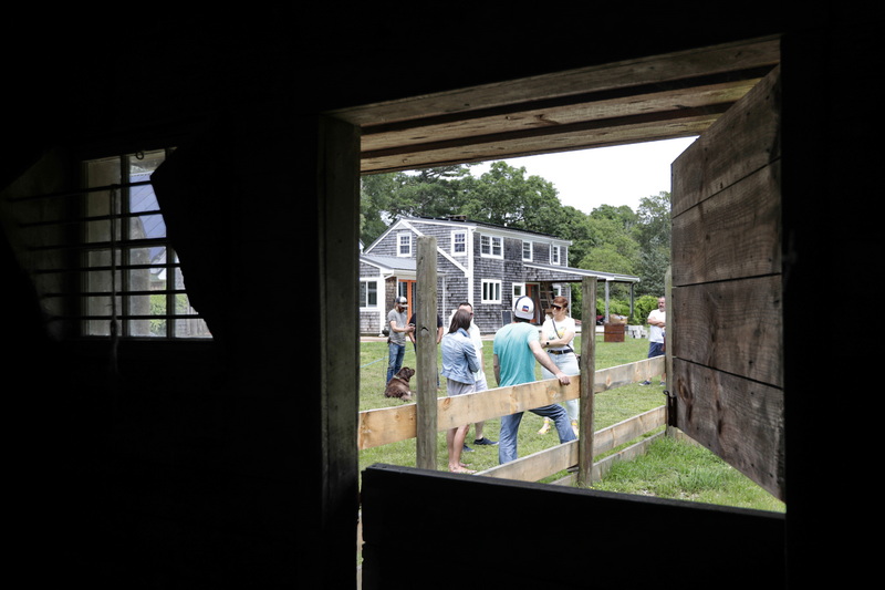 Guests chat outside of an old horse barn, which will be converted into a petting zoo, at a farm which is being converted into a center for autistic children in Dartmouth.  PHOTO PETER PEREIRA