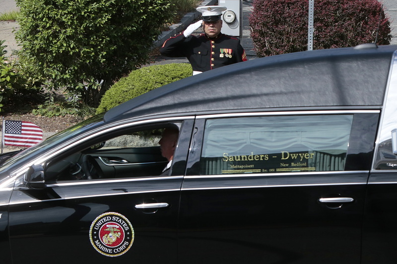 Current New Bedford police officer and fellow student of Dr. Waters, Cpl Christian Gomes (Ret.), stands at attention on Union Street and salutes the hearse carrying Dr. Herbert R. Waters, Jr., Colonel US Marine Corps (Ret.) as it drives past on its way to the funeral mass held at St. Julie Billiart church in Dartmouth. Dr. Waters was a leader in education and cultural community, especially known for his pride in his Wampanoag heritage.  PHOTO PETER PEREIRA