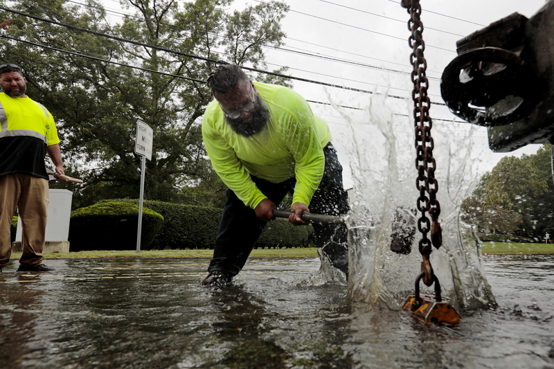 Felix Bruno-Galindez of New Bedford DPI, uses a sledgehammer in an effort to dislodge a manhole cover on Brownell Avenue in New Bedford, MA flooded due to the remnants of Ida.  PHOTO PETER PEREIRA